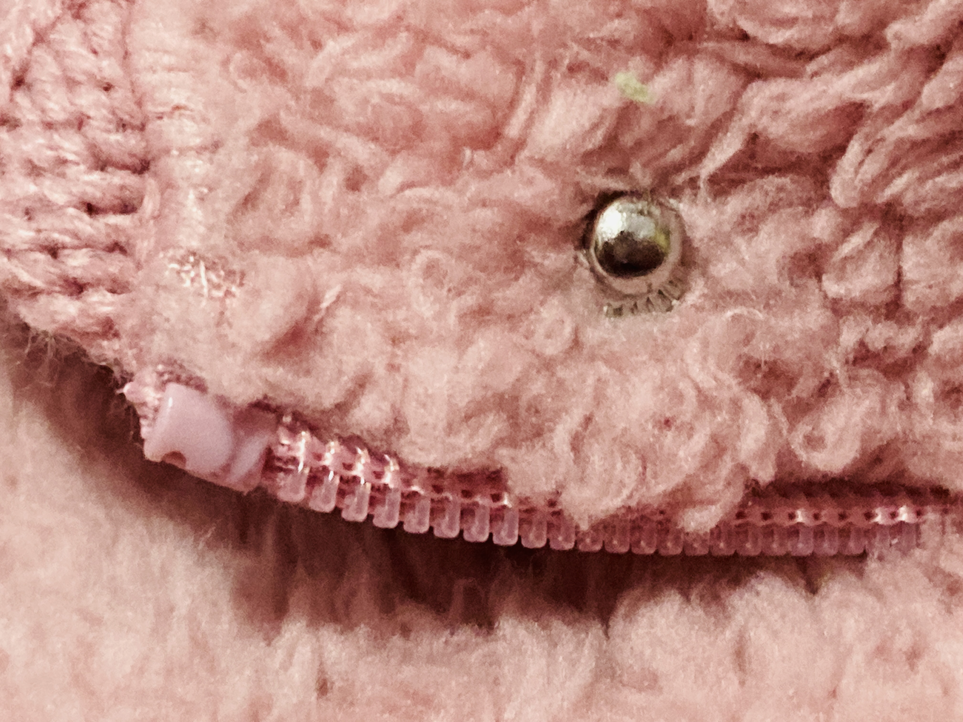 The button and zipper of a fluffy coat.